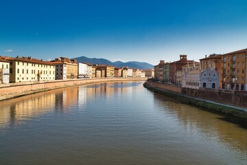 Obraz premium Scenic view of city buildings along the bank of a river in Italy