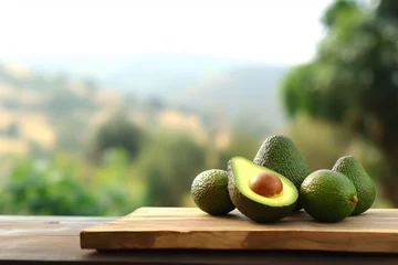 Fotobehang Fresh avocado on wooden table with blurred nature landscape background. © Sunday Cat Studio
