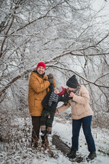 Fototapeta na wymiar family mom, dad, son portrait outdoors in the winter forest