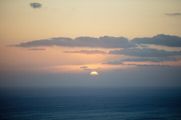 Fototapeta premium Sunset behind mountain silhouette over the sea on colorful sky background. Space