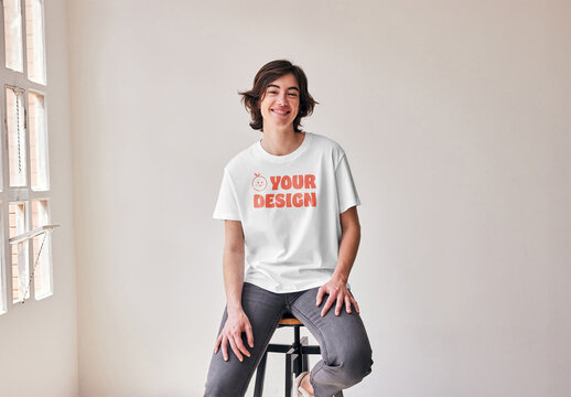 Mockup of young woman wearing customizable t-shirt on stool