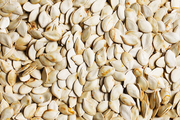 Dry pumpkin seeds texture. Pumpkin seeds roasted in oven background. Healthy snack. Vegetable seed closeup.