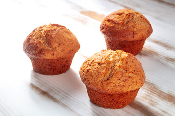 Orange muffins on a rustic wooden kitchen table, easy baking