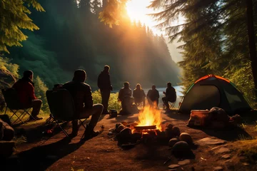 Tuinposter A group of people sitting in a campground around a campfire in the woods © Ungrim