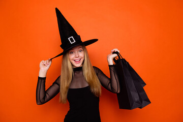Photo portrait of lovely blonde teen lady hold shopper bags packages wear black halloween garment...
