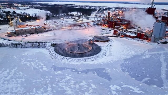 Aerial view around a vaporing pool at a pulp mill factory, winter morning in Oulu