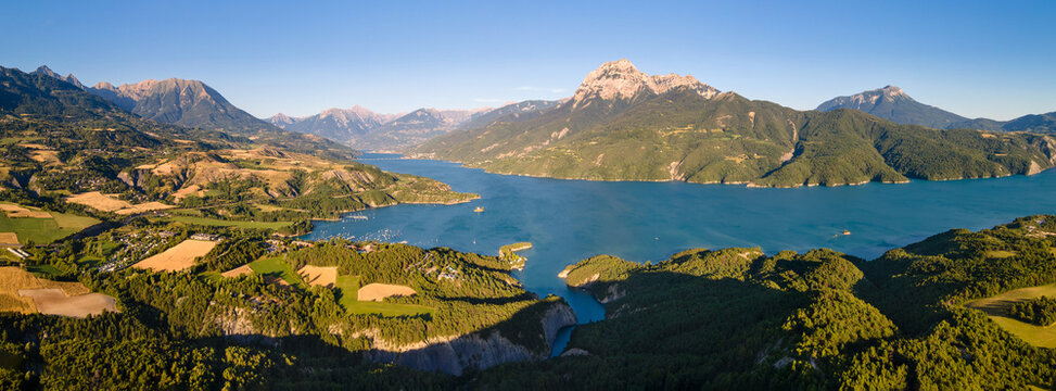 Summer aerial panoramic view of Serre-Poncon lake with Saint-Michel Bay and Grand Morgon peak in sunset light. Durance Valley in Hautes-Alpes (Alps), France