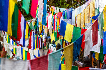 Colorful prayer flags on a bridge at Burning Lake a religious site in Jakar, Bumthang Valley,...