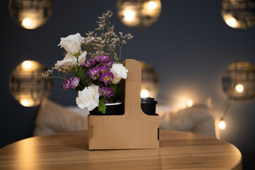 Bouquet of flowers in a paper bag on the kitchen table