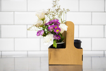 Bouquet of flowers in a paper bag on the kitchen table