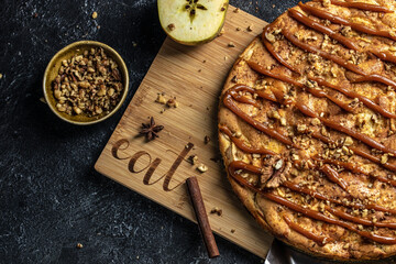 apple pie with caramel sauce on a wooden board. banner, menu, recipe place for text, top view