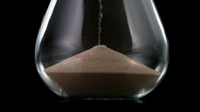 Sands move through hour glass, super slow motion filmed on high speed cinematic camera at 1000 fps