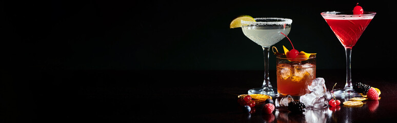 three sophisticated different cocktails garnished with berries and fruits, concept, banner