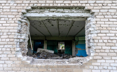 bomb hole in the wall destroyed school building in Ukraine