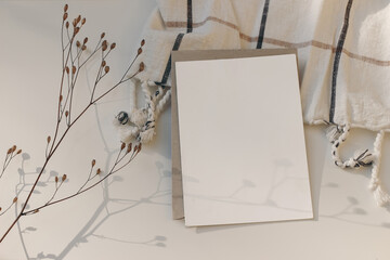 Closeup of empty Christmas greeting card, invitation mockup with dry flower and craft paper...