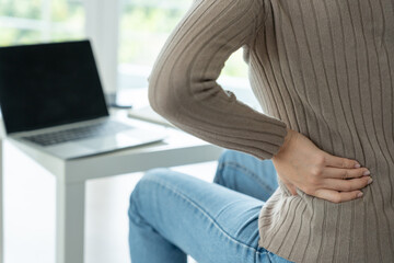 woman holding her lower back while and suffer from unbearable pain health and problems, chronic back pain, backache in office syndrome, scoliosis, herniated disc, muscle inflammation