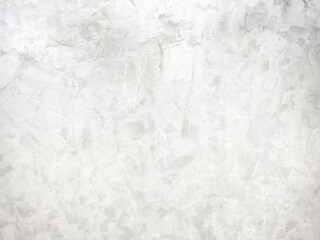 The light-colored cement wall has cracks.