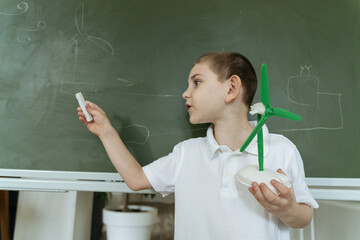 Kid shows and explains about wind generator model at school