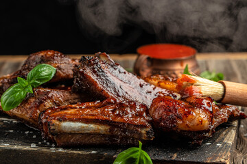 Hot grilled pork ribs with sauce and smoke on a wooden board. Restaurant menu, dieting, cookbook...