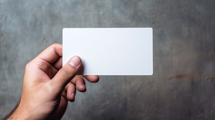 Person holding white business card on concrete wall background