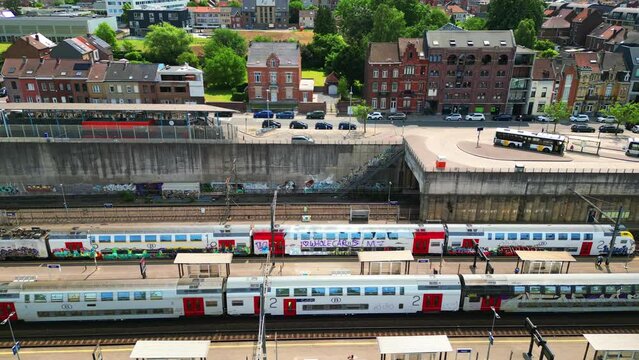 Breathtaking aerial footage showcasing the hustle and bustle at the Belgian Railway station (NMBS) of Halle, with trains departing and waiting on the platform. Aerial View of Halle Railway Station