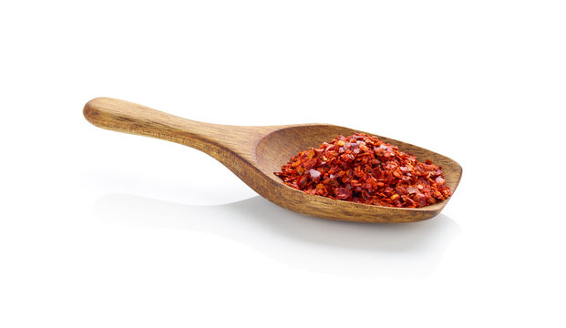 Crushed red pepper in wooden spoon isolated on white background