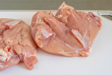 Raw chicken fillet on cutting board.