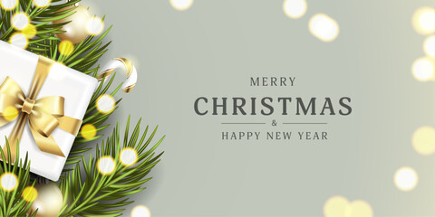 Realistic Christmas card on a gray background with fir green branches, golden Christmas tree decorations and a gift with a gold bow around glitter for the New Year holiday. Vector illustration.