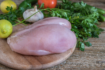 Raw chicken fillet on wooden cut board.