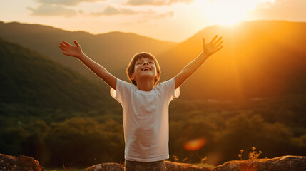 Boy kid wearing a white t-shirt joyfully raises his arms, his vibrant energy shining against a captivating nature landscape at sunset , portraying an aura of positivity and exuberance - obrazy, fototapety, plakaty
