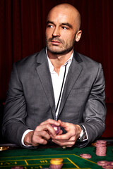Handsome man in grey suit playing casino
