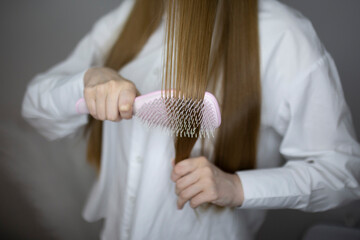a young girl combing her long hair close up shot