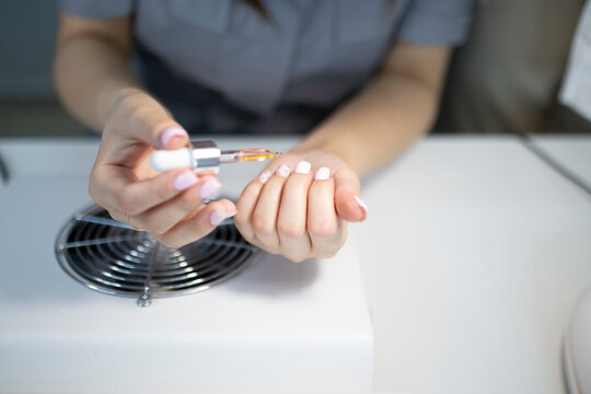 manicurist applying gel on the client's nail. protection cover