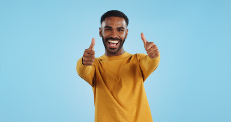 Happy, face and man with thumbs up in studio for support, motivation or vote on blue background. smile, portrait and excited male model with hand emoji for winning, thank you or success gesture