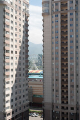 High-rise residential buildings in Almaty, Kazakhstan. View of the Ferris wheel and entertainment mall