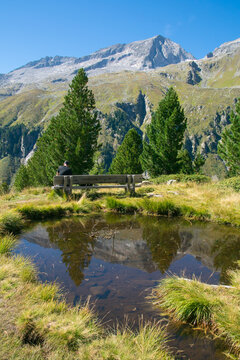 View of romantic bench near little alpine lake in Alto Adige, Italy