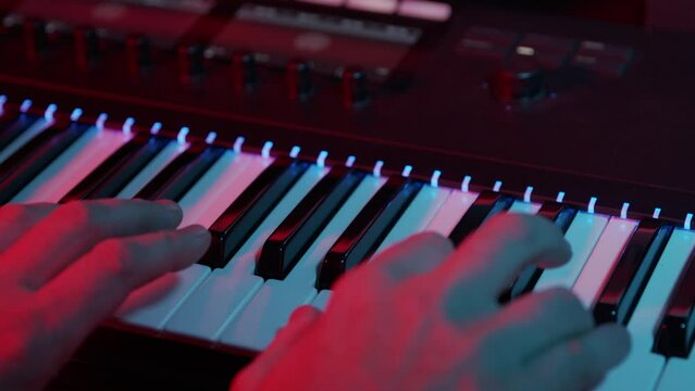 In the recording studio, piano keys on the piano, synthesizer keyboard being played close up.