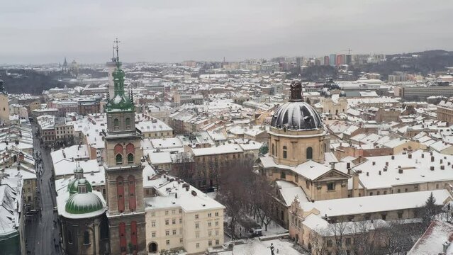 Aerial View Between Spires of Church and View of Town Hall, Church of Assumption of Blessed Virgin Mary, and Dominican Cathedral. Drone Shot of Old Winter City Lviv, Ukraine