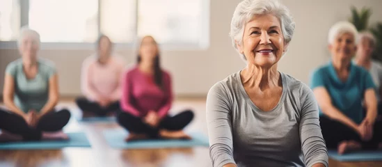 Tuinposter Group exercise for healthy lifestyle wellness and self care in a pilates studio focusing on yoga fitness senior women training and retirement health With copyspace for text © 2rogan