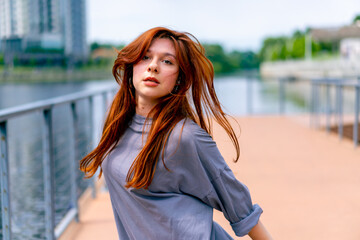young red-haired street hip-hop dancer in sportswear dances impromptu dance us bridge attract the...
