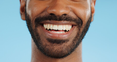 Smile, closeup and black man with teeth in studio, blue background and mockup space with happiness...