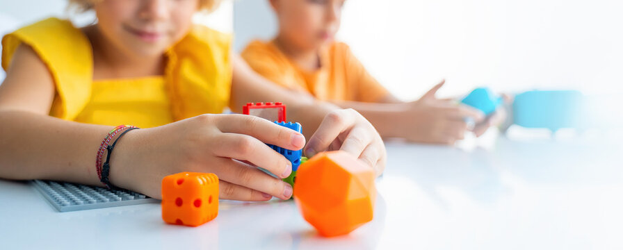 Robotics programming class. Preschool Children construct and code Robot. STEM education using constructor blocks and laptop, remote control joystick. Technology educational development for school kids