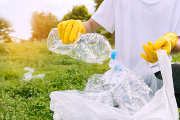 Volunteer teenage boys are holding garbage bags and Collecting plastic bottle waste at public parks...