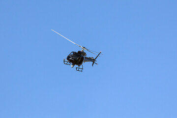 A helicopter crosses the blue sky with clouds. Transportation. Urban.