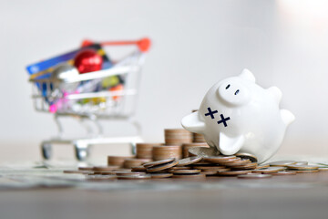 The dead piggy bank lies upside down on coins, Economic crisis, Decrease, layoff, job fired, pay...