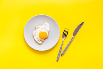 Fast breakfast with one fried egg on plate, top view