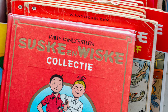 Stack of old Dutch Red Series comic books of Suske en Wiske, in English: Spike and Suzy, on an antique fair in Rheden, The Netherlands on August 13, 2023