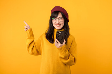 Embracing digital life. Woman in a red beret and yellow sweater uses a smartphone against a...