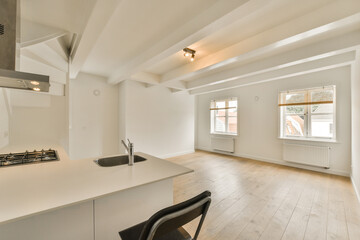 an empty kitchen and dining area in a house with white walls, wood flooring and exposed ceiling beams on the room is very