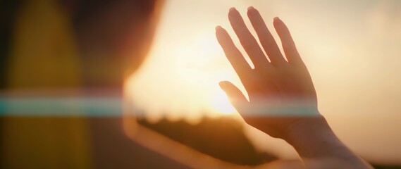 Woman streches her hand to setting sun. Girl touches the rays of light.